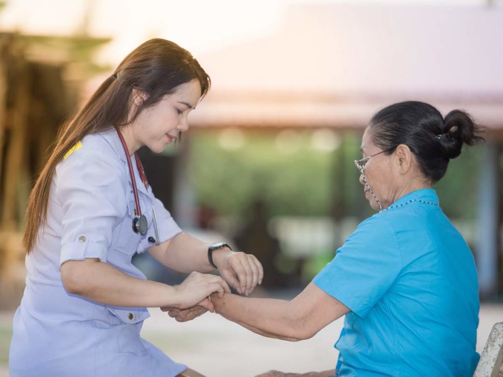 nurse helping elderly woman
